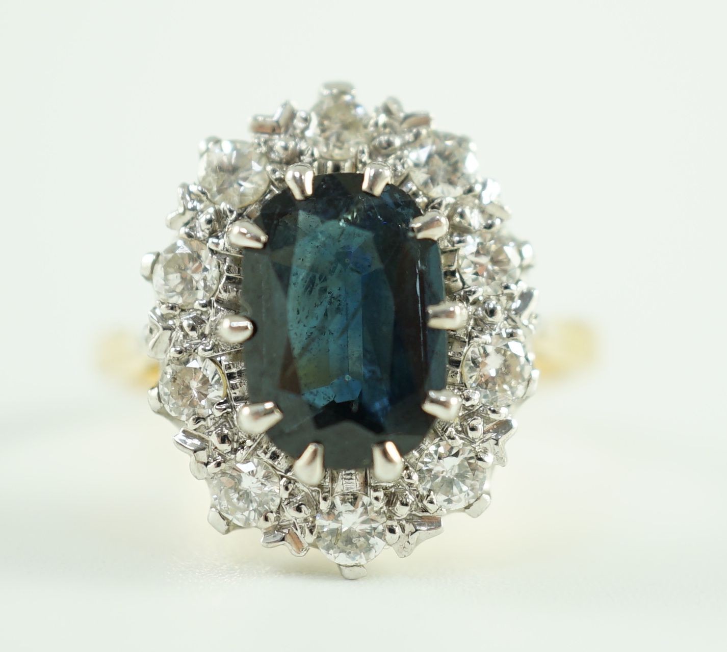 An 18ct gold, sapphire and diamond set oval cluster dress ring